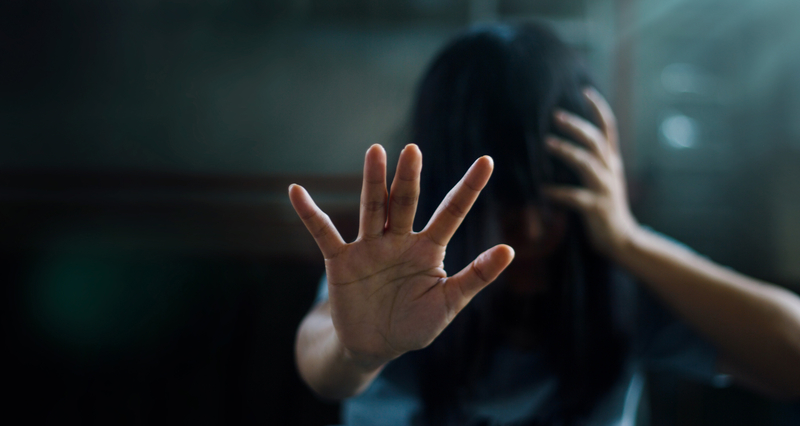 A hand holding a flickering flame, symbolizing the enduring "sparks" of human drives like hope and creativity that persist even in the darkness of severe mental illness.