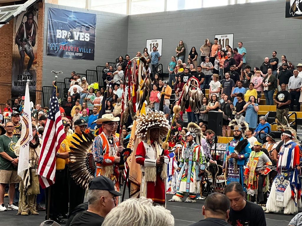 Dancers in colorful regalia enter the arena as drum groups perform during the Lumbee Tribe powwow.