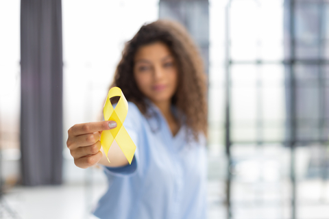 Illustration of diverse young woman standing with a ribbon for suicide prevention awareness