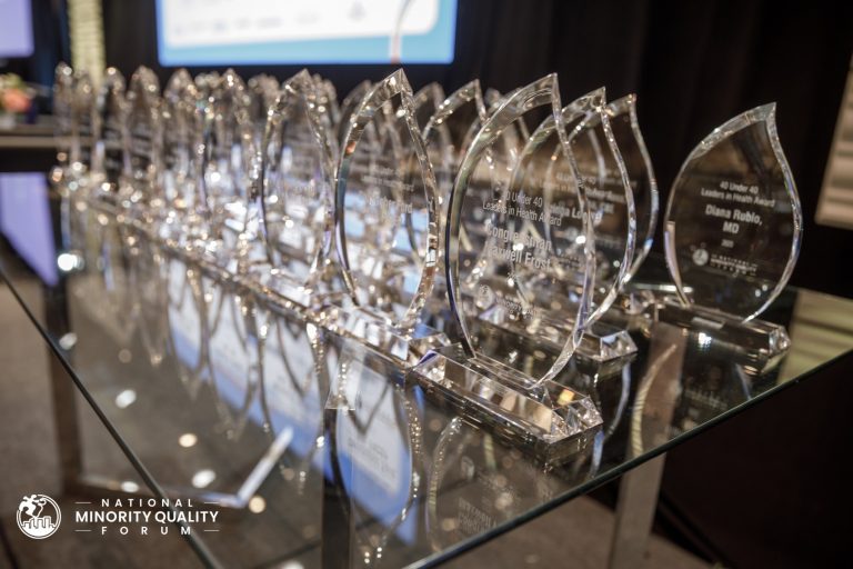 A previous National Minority Quality Forum 40 Under 40 honoree receives their award on stage during the NMQF Leadership Summit on Health Disparities in Washington, D.C.
