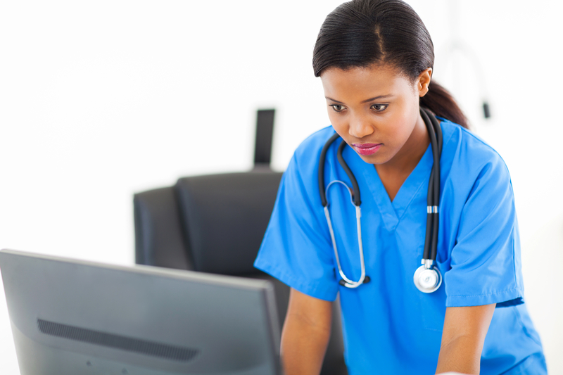 A nurse practitioner reviews patient information on a computer using AI-powered clinical decision support technology in a community healthcare setting.